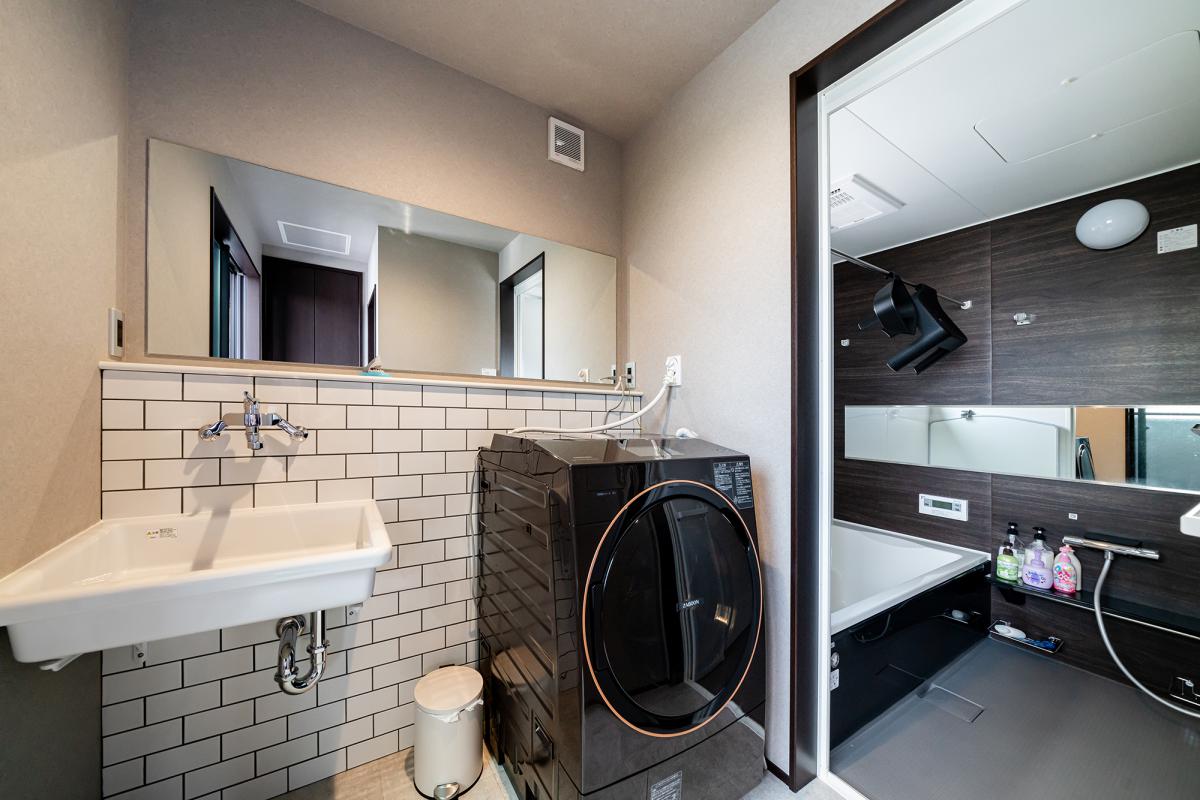 ”サブウェイタイルと一面の鏡が印象的なモノトーンでまとめた洗面＆浴室