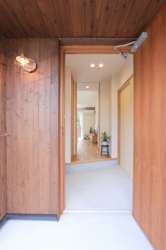 玄関まわりは、チークの無垢扉が馴染む温かみのある色合いで統一。 選んだ天然木の玄関扉は、使うほどに深みを増すだけでなく、高い断熱性能を有します。